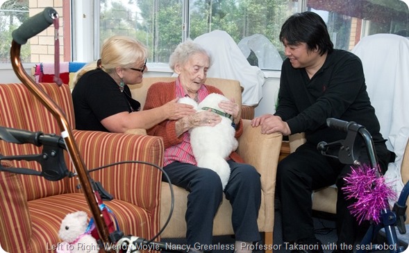 Professor Takanori is in Australia from Japan to meet with Professor Wendy Moyle to talk about the robots for dementia. At Sinnamon Park Retirement Village.L to R Wendy Moyle, Nancy Greenless, Professor Takanori with the seal robot